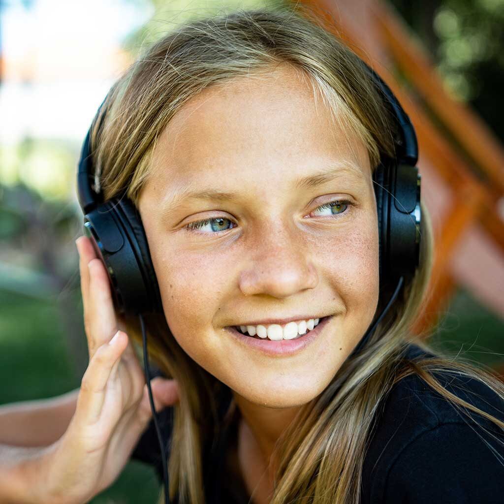 Young girl with headphones on looking offscreen